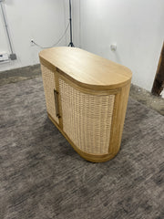 Front view of the Anthropologie Sienna oak wood entryway cabinet with woven rattan doors